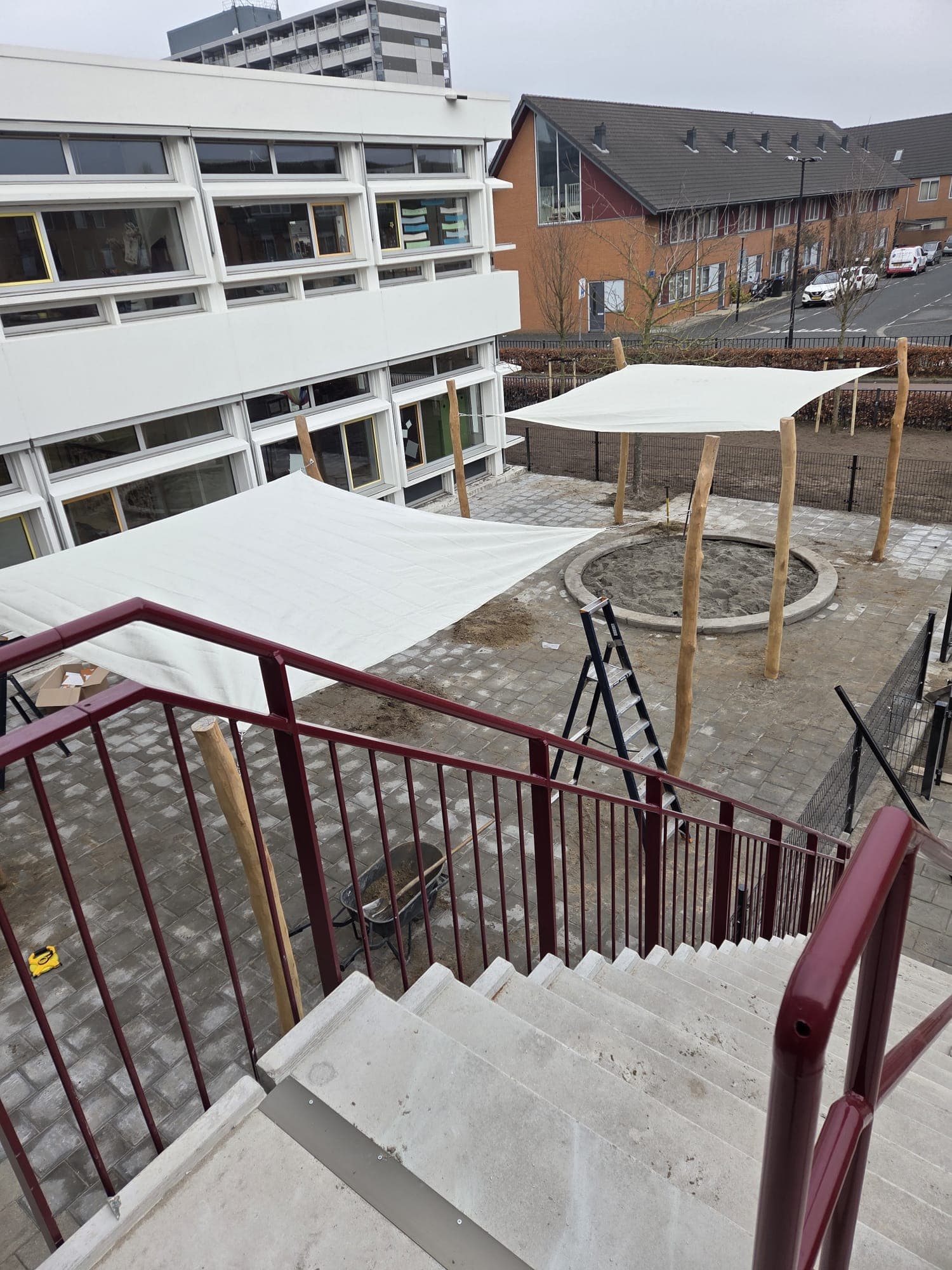 Zonnezeilen en bestrating bij schoolplein